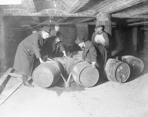 Federal Prohibition agents destroying barrels of confiscated alcohol. Agents at the Nikko Inn in Croton went undercover as musicians before making arrests.